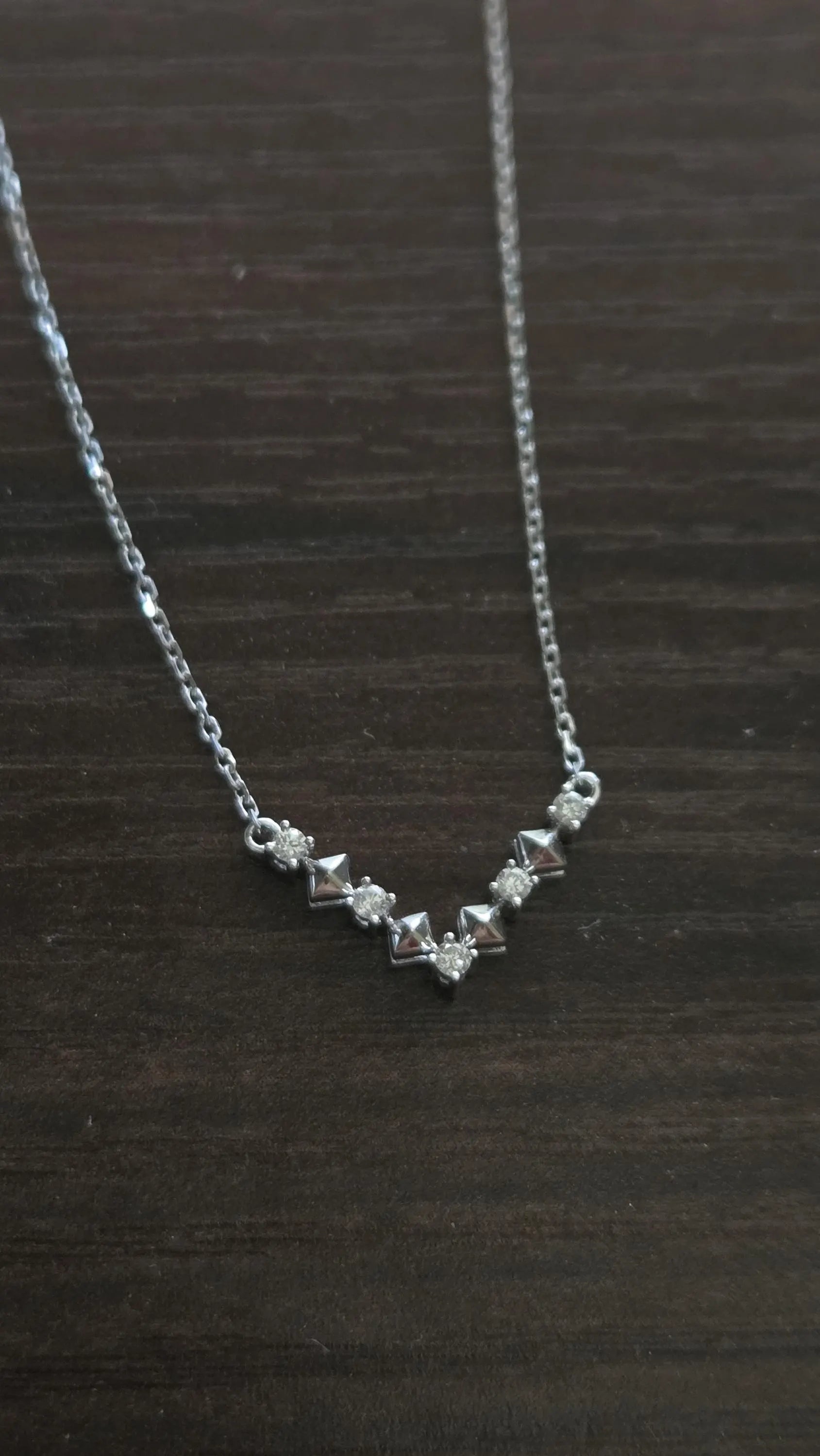 Darry Ring DR Paris V Necklace on dark surface