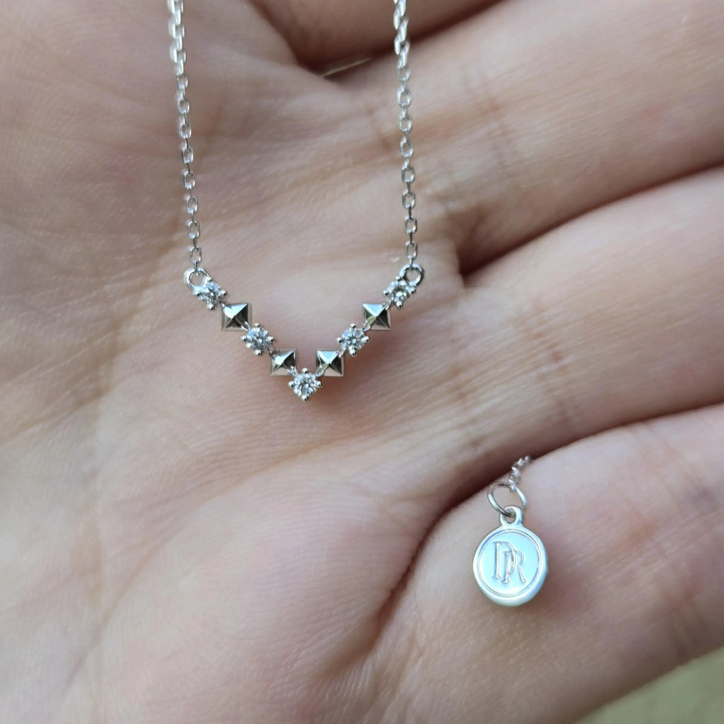 Darry Ring DR Paris V Necklace in hand showing DR logo tag